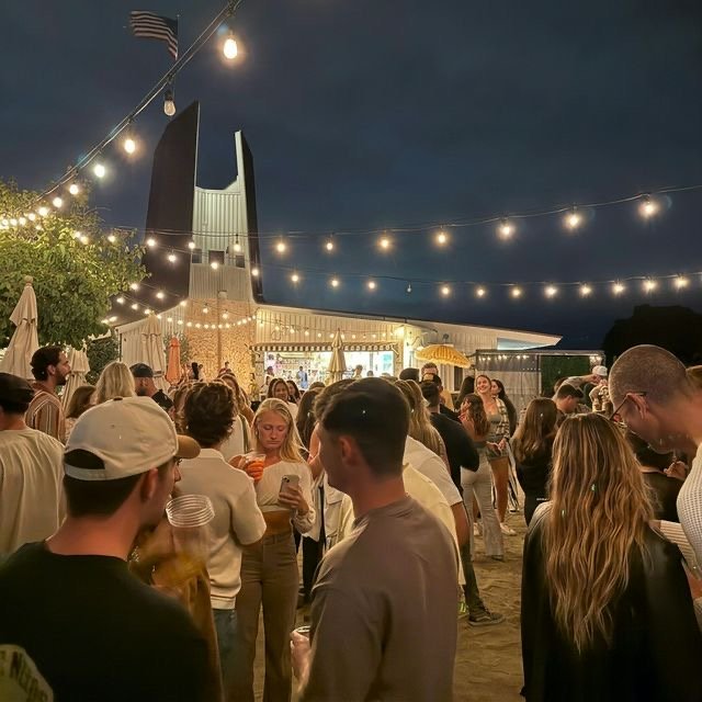 Friends gathered under string lights on the Beach Club patio